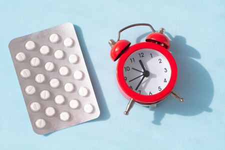red alarm clock and pills. Time reminder for taking pills.Medicine in hospital.