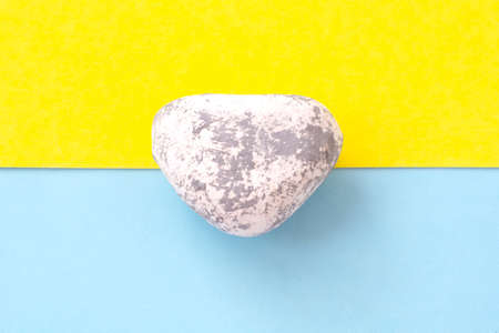 Sea stone on a blue and yellow background, vacation on the seaの写真素材