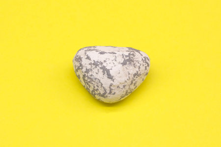 Sea stone on a yellow background, vacation on the seaの写真素材