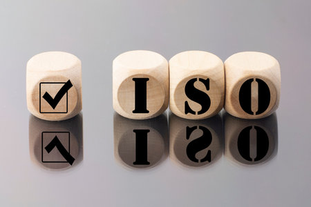 abbreviation ISO on wooden cubes with check mark. ISO quality control certification approval concept.の写真素材