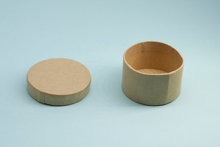 Round craft box with open lid on blue background.の写真素材