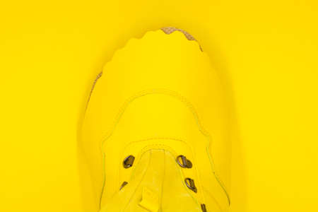 Women's yellow shoe on a yellow background. Fashion conceptの写真素材