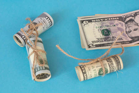 Twisted bundle 100 dollar bills on a blue background. Business conceptの写真素材
