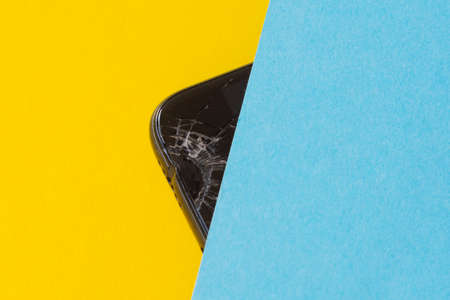 broken black mobile phone, screen crack on yellow backgroundの写真素材