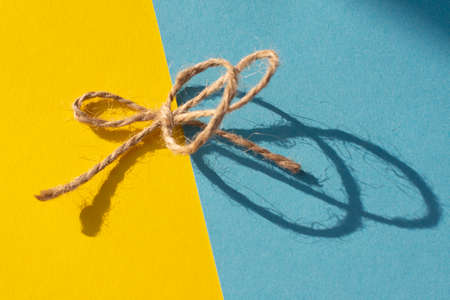 the thread is linen with a shadow on a yellow-blue background. Summer or holiday conceptの写真素材