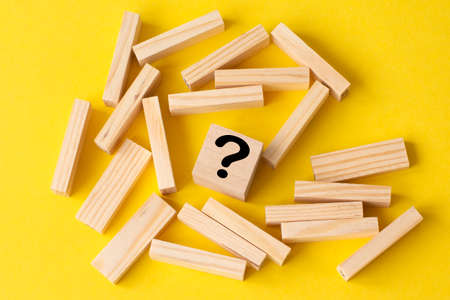wooden blocks with a wooden cube with question mark in the middle. Business strategy, problem solving, challenge or obstacle concept.の写真素材