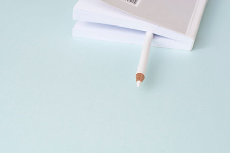 white pencil between the pages of the book on a blue background