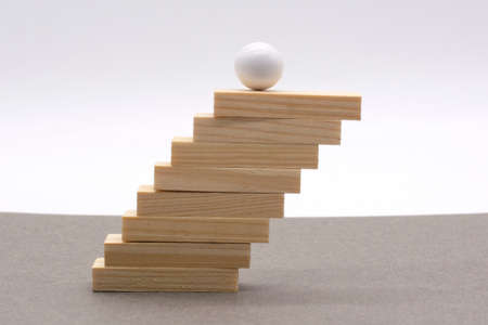 Wood block stacking as step stair and white ball. Business concept growth successの写真素材