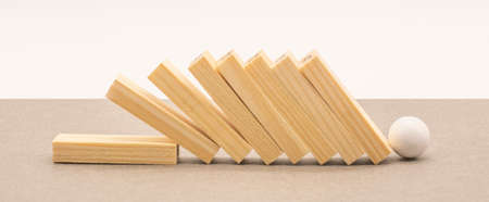 Fallen wooden blocks and a white ball. The concept of business leadershipの写真素材