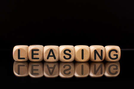 blocks with the word Leasing with a reflection on a black background.の写真素材