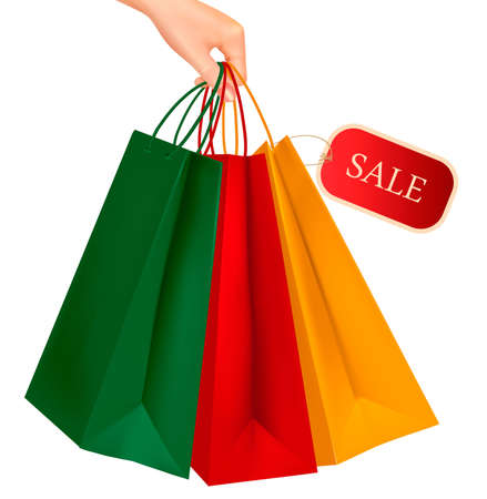 Female hand holding colorful shopping bags with sale tag. Concept of discount. Vector illustration.のイラスト素材