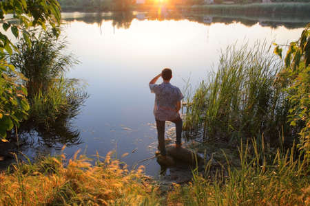 It depicts a young man on the river, looking into the distanceの写真素材