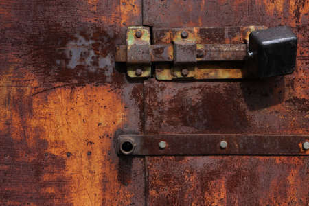 Door lock hangs on a rusty gateの写真素材