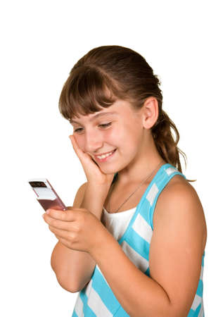 The smiling girl with a mobile phone on a white backgroundの写真素材