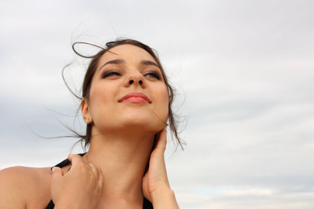 Beautiful smiling girl, brunette against the skyの写真素材