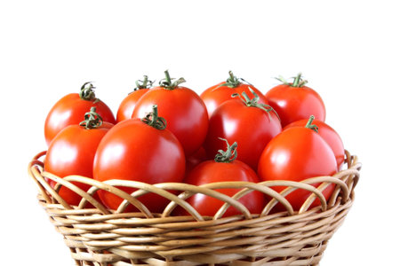 Tomatoes with tails in a basket on a white backgroundの写真素材