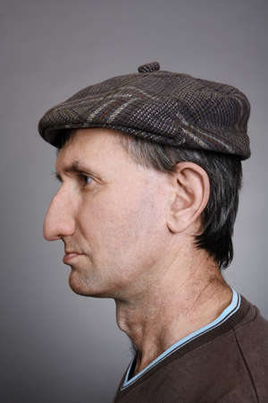 Portrait of a man in a cap in profile on a gray backgroundの写真素材