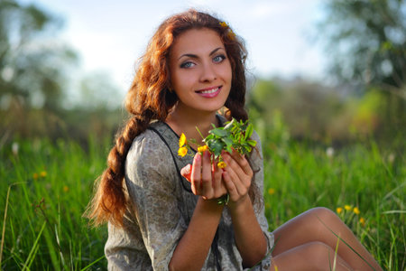 Beauty girl in dress on the meadow, with flowers in their hands