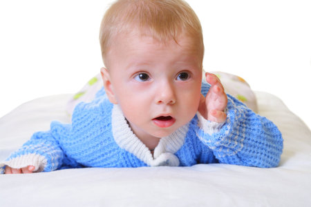 Child is lying on his stomach on a white background