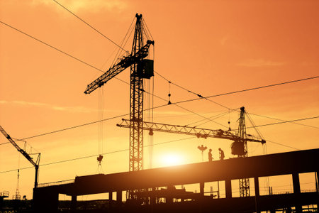 Construction cranes and construction workers on building site