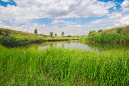 Countryside landscape, river coast Ingulets against the sky with cloudsの写真素材