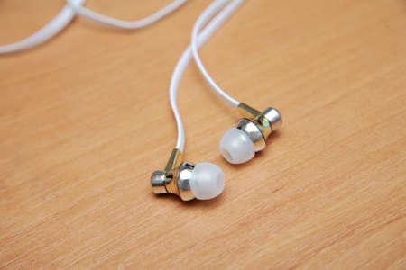 Headphones for the phone are on the table close-upの写真素材
