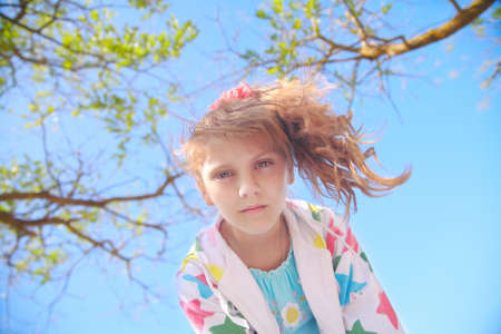 Little girl in the nature looks at the camera top downの写真素材