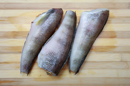 Three pieces of fish notothenia on a cutting board close-up