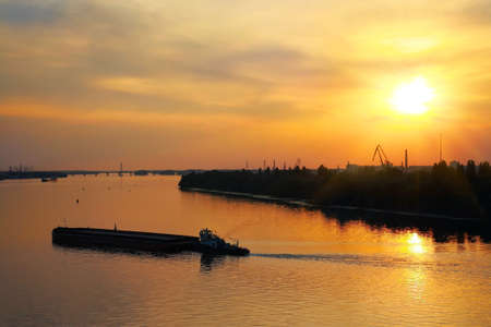 Industrial Landscape, barge sails on the river at sunsetの写真素材
