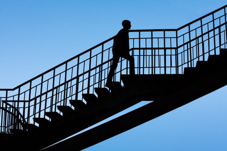 A man walks down the steps against the sky, silhouette