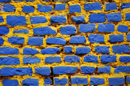 Brick wall painted in blue and yellowの写真素材