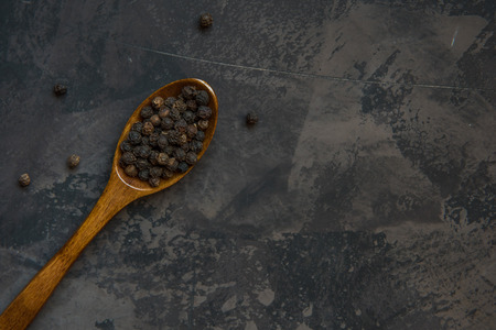Black pepper on a wooden spoon, copy space.の写真素材