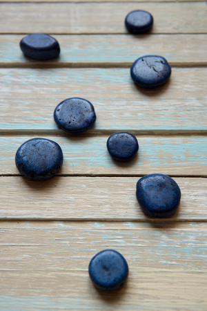 Blue decorative stones on a wooden background.の写真素材