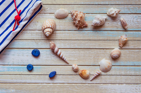 Seashells shaped heart on a wooden background top view.の写真素材