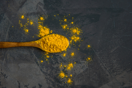 Turmeric powder on a wooden spoon, copy space.の写真素材