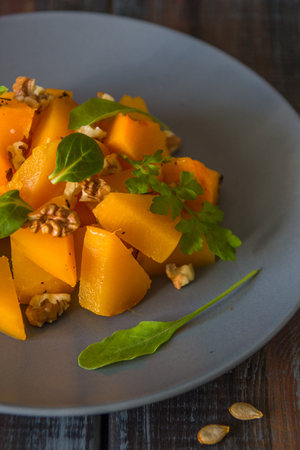 Salad with pumpkin, walnuts and green leaves.の写真素材