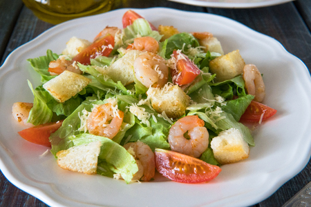 Caesar salad with shrimps, cherry tomato, croutons, salad leaf and parmesan cheese.の写真素材