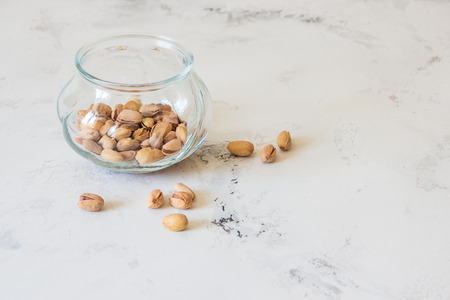 Pistachios in glass jar on the white tableの写真素材