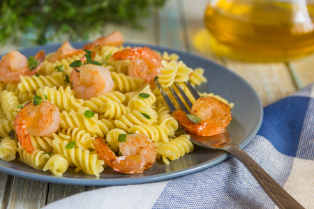 Italian pasta fusilli with shrimps and thyme.の写真素材