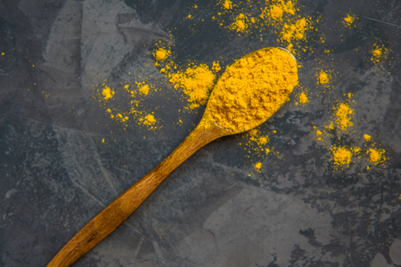 Turmeric powder on a wooden spoon, copy space.の写真素材
