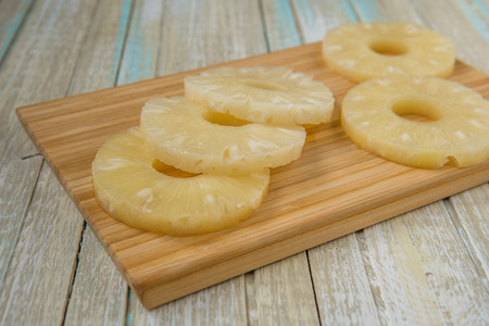 Pineapple rings on a wooden board. Canned ananas slices.の写真素材