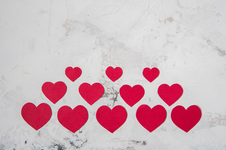 Red paper hearts on a white texture background, copy space.の写真素材
