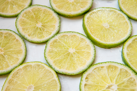Lime slices in rows on a light background top view.の写真素材