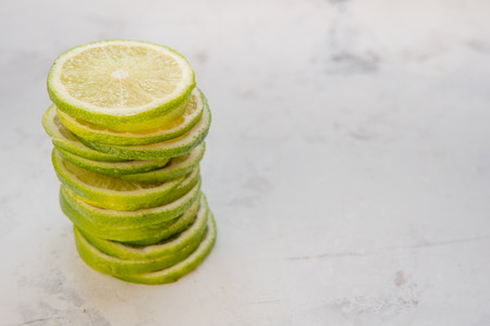 Pile of lime slices on a light background.の写真素材