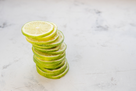 Pile of lime slices on a light background.の写真素材