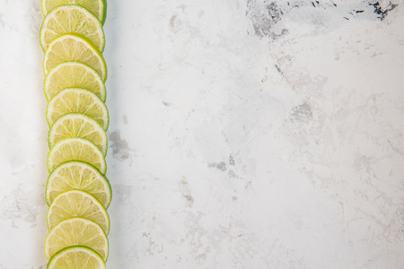 Lime slices in row on a light background copy space.の写真素材