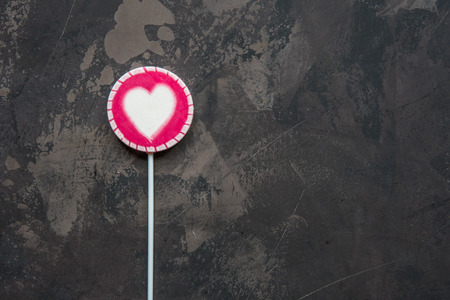 Pink lollipop with white heart top view.の写真素材
