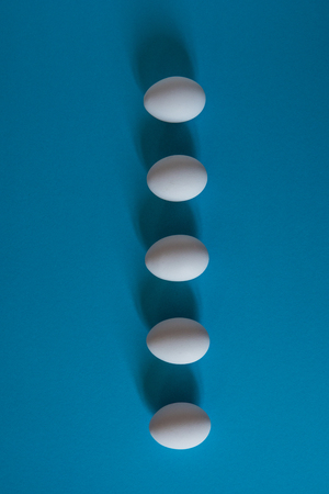 White eggs on a blue background top view.の写真素材