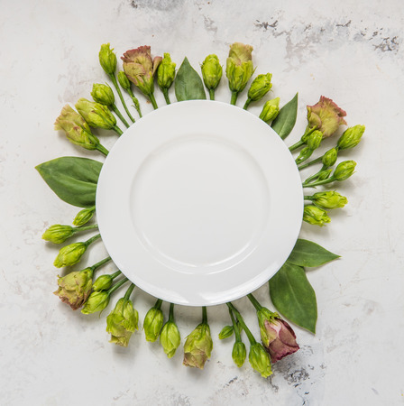 Empty plate framed flowers, top view. Plate over lisianthus on a light background.の写真素材