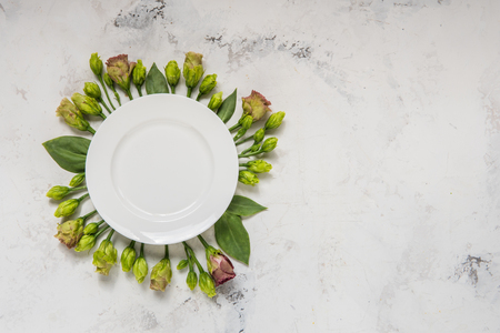 Empty plate framed flowers, top view. Plate over lisianthus on a light background.の写真素材